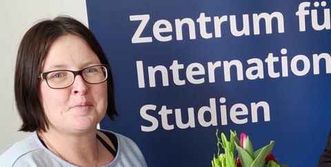 Links: Anke Born; Hintergrund: Aufsteller des Zentrums für Internationale Studien