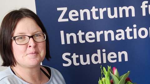 Links: Anke Born; Hintergrund: Aufsteller des Zentrums für Internationale Studien