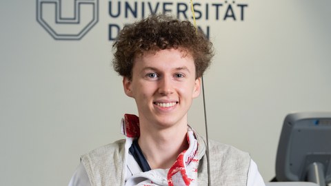 Portraitfoto von Laurenz Rieger in Fechtkleidung mit Florett