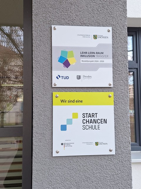 Schulplakette an einer Gebäudewand einer Schule. "Wir sind eine START CHANCEN SCHULE"