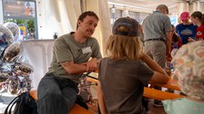Junger Mann spricht mit Kind