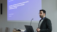 Auf dem Bild ist Dr. Sam Toorchi Roodsaari bei seiner Keynote zum Thema „Kompetenz- und outputorientiertes Lernen mit KI: ein adaptives Feedbacksystem am Beispiel des Westermann-Verlags“  zu sehen