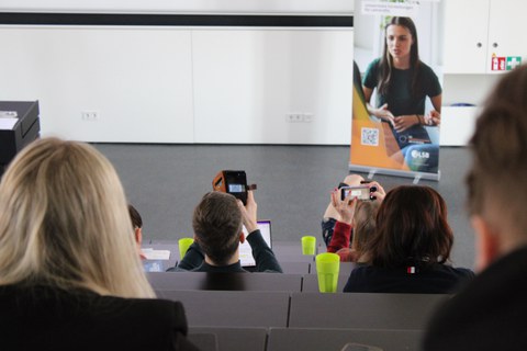 Teilnehmende scannen QR-Code im Hörsaal