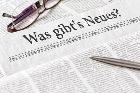 Zeitung mit Kugelschreiber und Brille