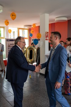 Zwei Männer schütteln sich lächelnd die Hand.