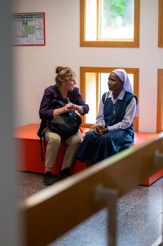 Zwei Frauen sitzen nebeneinander und unterhalten sich