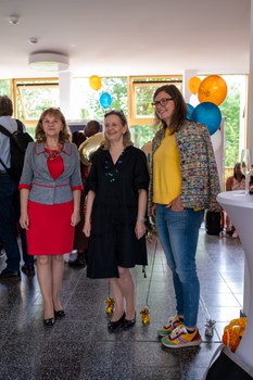 Drei Frauen stehen nebeneinander für ein Foto aus einer anderen Kamera.