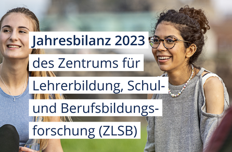 2 junge Frauen sitzen auf einer Wiese und lachen dabei.