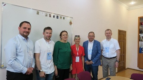 Gruppenbild von sechs Erwachsenen, die in einem Raum der Universität Kazan stehen.