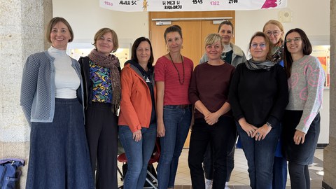 Gruppenbild mit 10 Personen vor Schuleingang