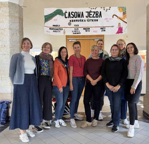 Gruppenbild mit 10 Personen vor Schuleingang