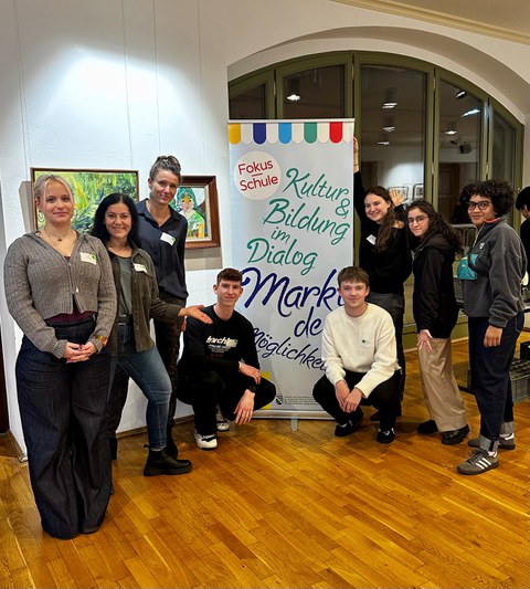 Gruppenbild mit 8 Personen um ein Roll-Up