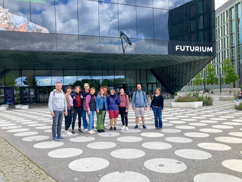 Eine Gruppe von ca. 10 Personen steht vor einem großen dunklen Gebäude (Futurium Berlin)