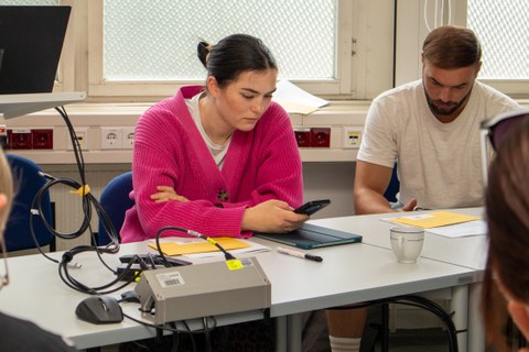 Junge Frau sitzt am Smartphone