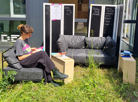 Frau sitzt auf Sofa und liest Buch