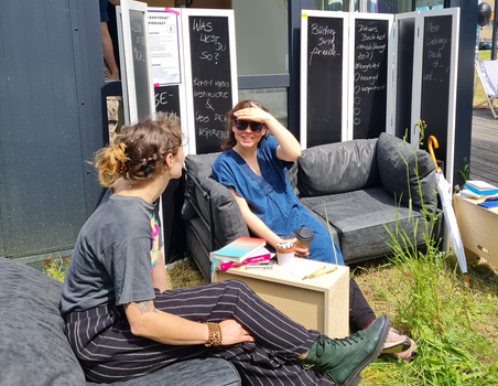 Zwei Frauen sitzen auf Sofa und unterhalten sich