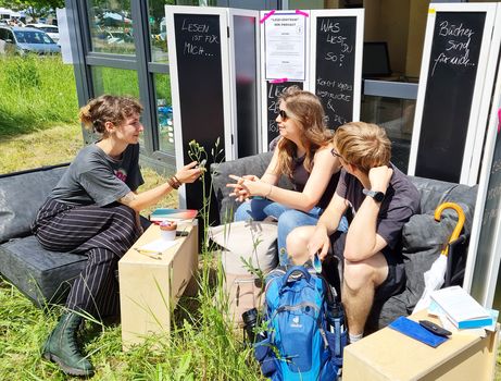 Drei Frauen sitzen auf Sofa und unterhalten sich