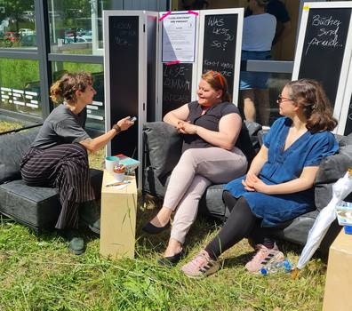 Drei Frauen sitzen auf Sofa und unterhalten sich