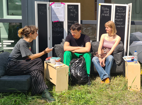 Drei Frauen sitzen auf Sofa und unterhalten sich