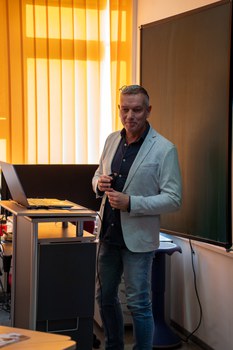 Mann hält Vortrag und steht dabei an einem Pult