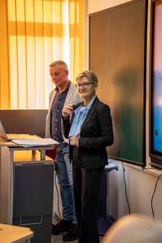 Frau hält Vortrag und steht an einem Pult.