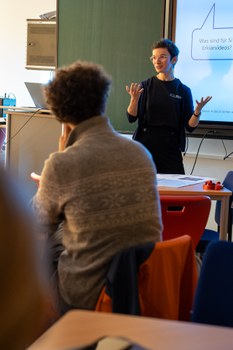 Frau hält Vortrag vor einer interaktiven Tafel