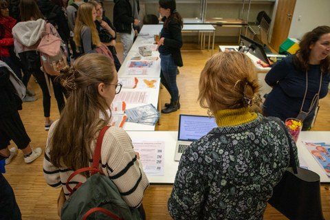 2 Studentinnen gucken sich Informationsmaterialienan einem Infostand an