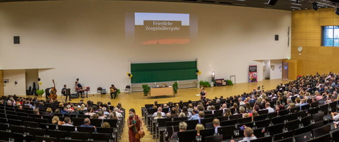 Auf dem Bild sind die Teilnehmenden der feierlichen Zeugnisübergabe 2022 im Audimax der TU Dresden zu sehen.