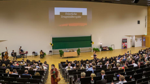 Auf dem Bild sind die Teilnehmenden der feierlichen Zeugnisübergabe 2022 im Audimax der TU Dresden zu sehen.