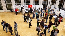 Eine Gruppe von Studierenden informiert sich an Ständen zu Auslandsaufenthalten.