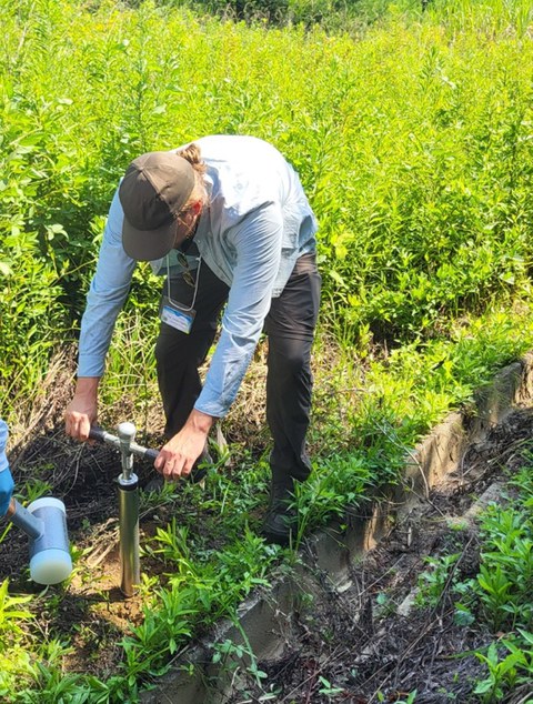 Junger Mann entnimmt Bodenprobe 