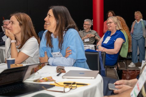Mehrere Personen sitzen an einem Tisch und lachen zusammen