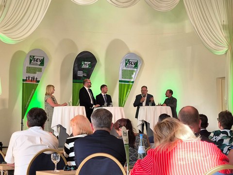 Das Foto zeigt die Teilnehmenden der Podiumsdiskussion der berufspolitischen öffentlichen Veranstaltung. Von links nach rechts sind Petra Müller, Christian Piwarz, Michael Kretschmer, Axel Gehrmann und René Michel zu sehen.