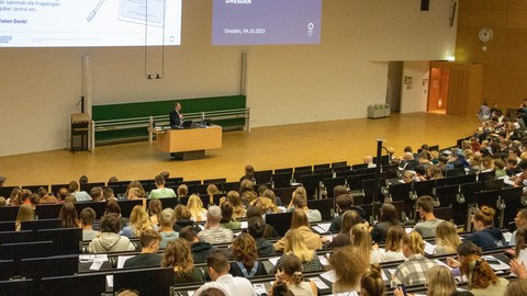 Professor hält Vortrag in einem Hörsaal voller Studierender.