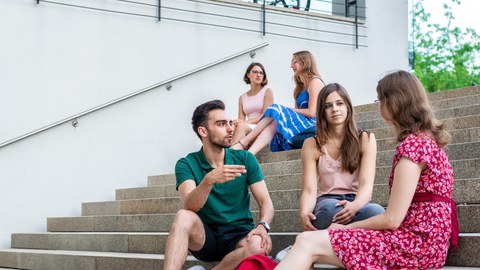 Studierende unterhalten sich auf dem Campus