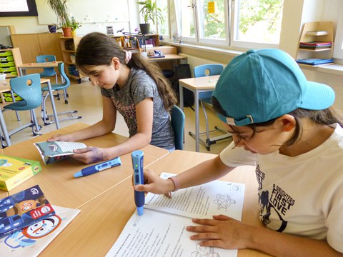 Zwei Mädchen arbeiten an einem Tisch mit inklusivem Lernmaterial