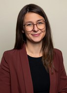 Portrait einer weiblichen Person mit langen Haaren und Brille