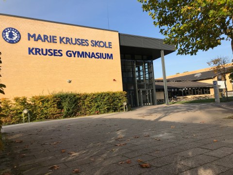 Das Foto zeigt ein Schulgebäude, auf dem "Marie Kruses Skole – Kruses Gymnasium" steht.