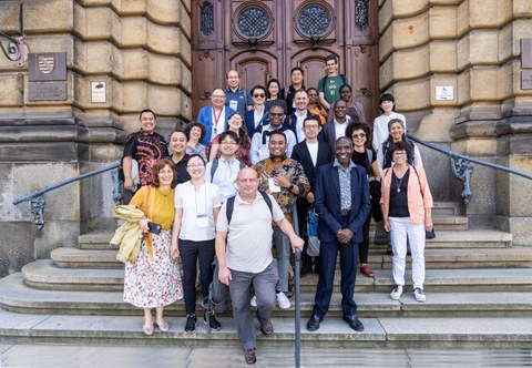 Eine Gruppe von ca. 20 Personen auf einer Treppe aufgereiht vor dem Eingang eines alten Ministeriumsgebäudes.