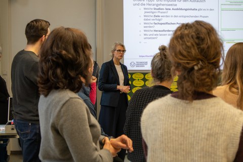 Foto: Mehrere Personen stehen beisammen und unterhalten sich.