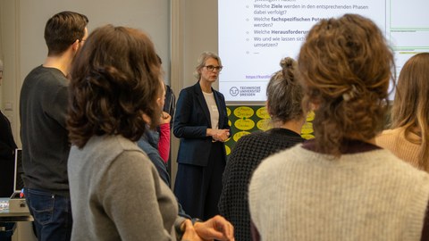 Foto: Mehrere Personen stehen beisammen und unterhalten sich.