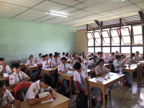 Foto eines Klassenzimmers, wo die Schüler:innen weiße Schuluniform tragen