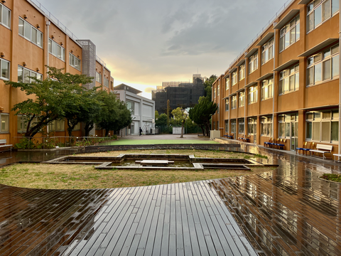 Zu sehen ist ein Innenhof einer Universität. Links und rechts im Bild sind zwei lange Gebäude, die den Hof umranden.