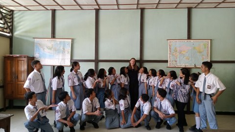 Auf dem Foto ist eine indonesische Schulklasse zu sehen, die sich für Gruppenbild in zwei Reihen aufgestellt hat.