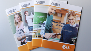 Das Foto zeigt vier Broschüren mit Informationen zu den Lehramtsstudiengängen, die auf einem Tisch aufgefächert sind.