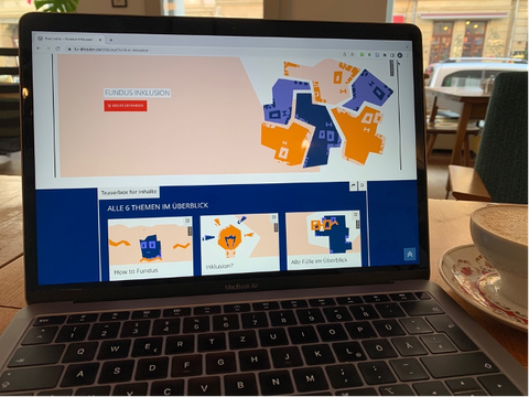 Foto: Ein Laptop steht auf einem Tisch. Auf dem Monitor ist die Webseite "Fundus Inklusion" zu sehen.