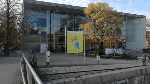 Frontalansicht des Hörsaalzentrums der TU Dresden. Auf einem großen Banner vor dem Gebäude steht "Tag der Lehre".