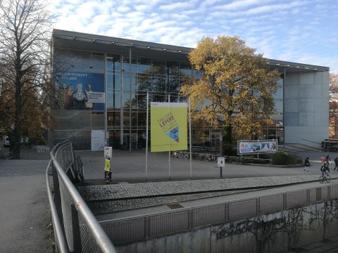 Frontalansicht des Hörsaalzentrums der TU Dresden. Auf einem großen Banner vor dem Gebäude steht "Tag der Lehre".