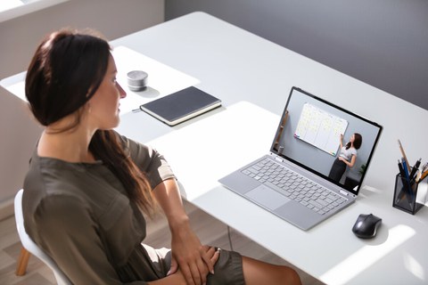 Foto: Person sitzt vor einem Laptop