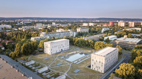 Das Foto zeigt eine Luftaufnahme der Gebäude der Sächsischen Landes- und Universitätsbibliothek. Zwischen den beiden Hauptgebäuden befindet sich eine große Grünfläche. Diese ist von einem Netz aus kleinen Wegen durchzogen.
